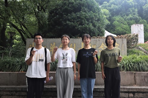 计算机202班团支部第7小组队员手持校徽打卡红色教育基地